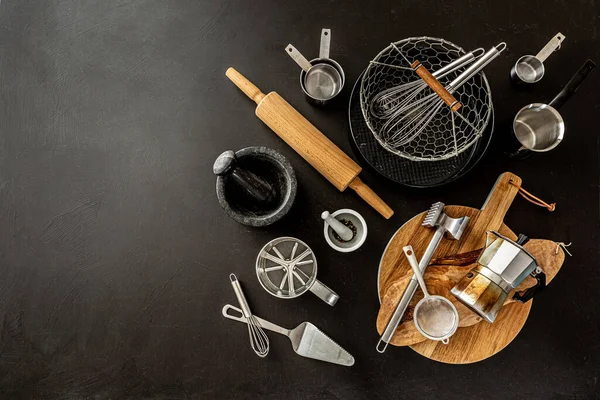 Set of black kitchen utensils and cooking tools neatly arranged on countertop