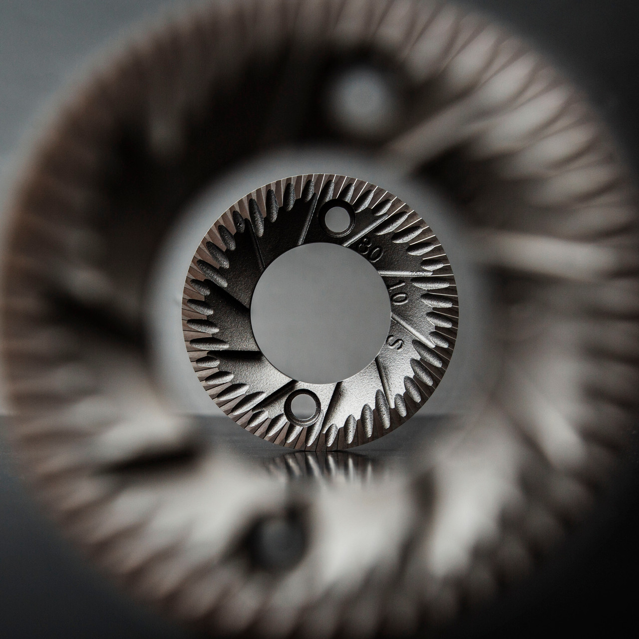 Close-up of steel coffee grinder burrs showing the cutting edges