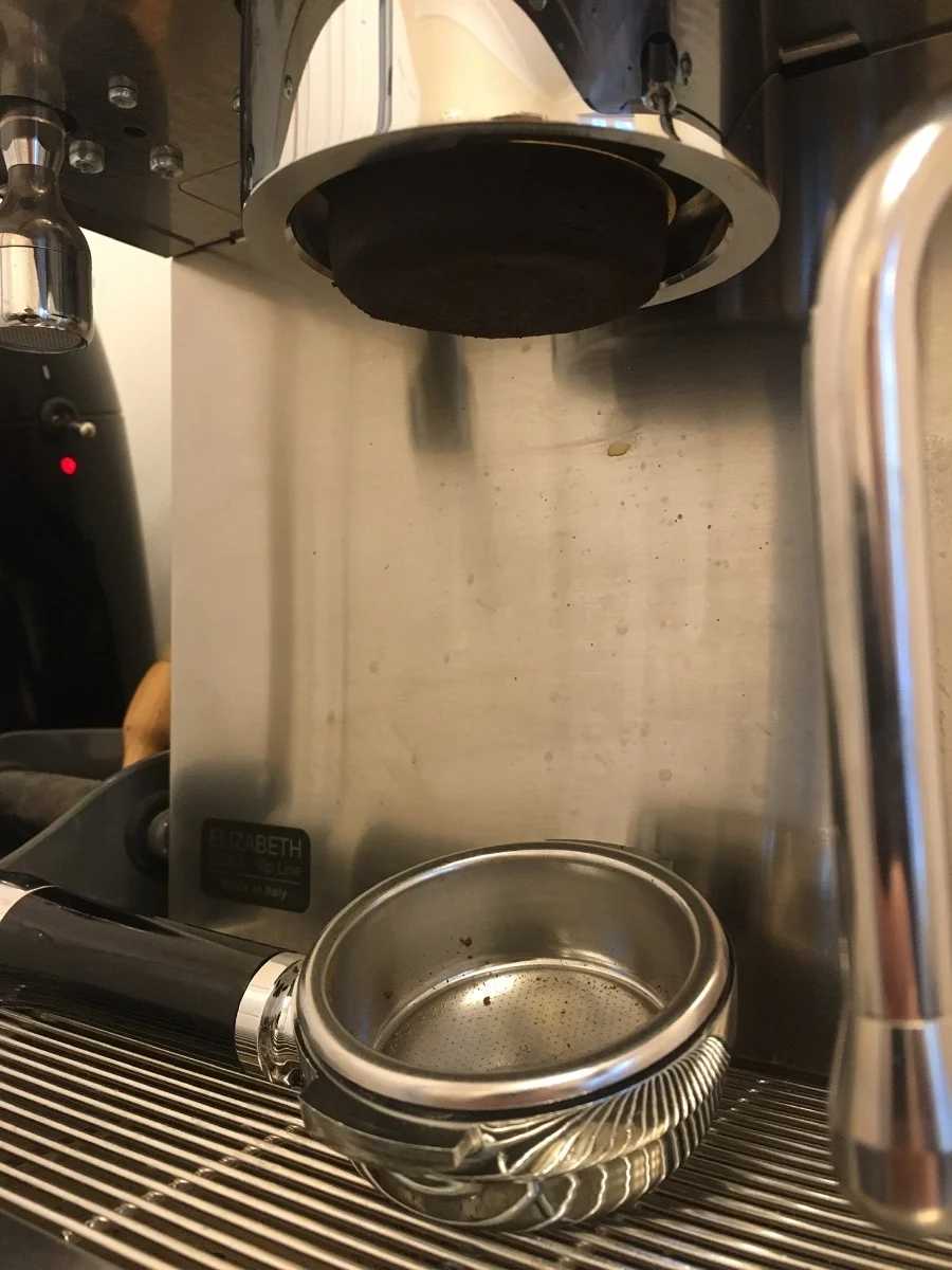 Coffee maker brew head and filter basket removed showing internal blockage