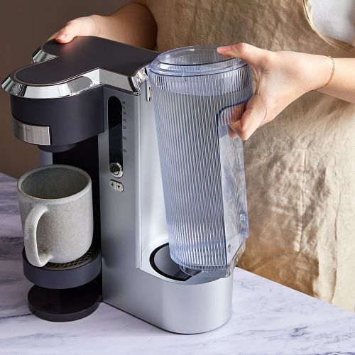 Removing the water tank from a coffee maker to clean and descale it