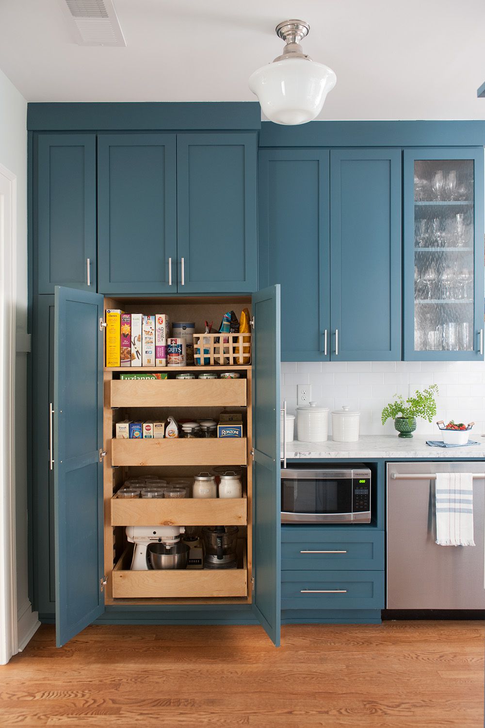 Pull-out pantry cabinet with shelves used to store kitchen appliances and dry goods neatly