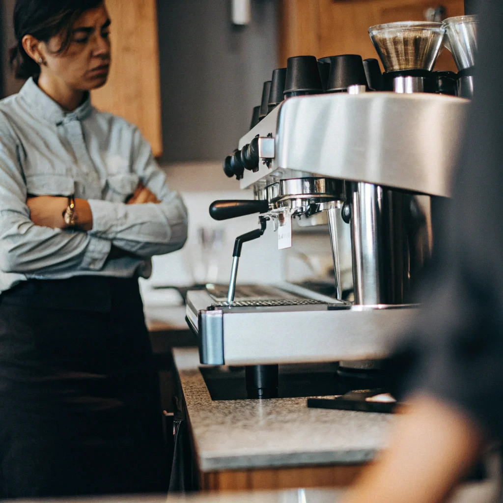 Frustrated person looking at a coffee machine that is not brewing
