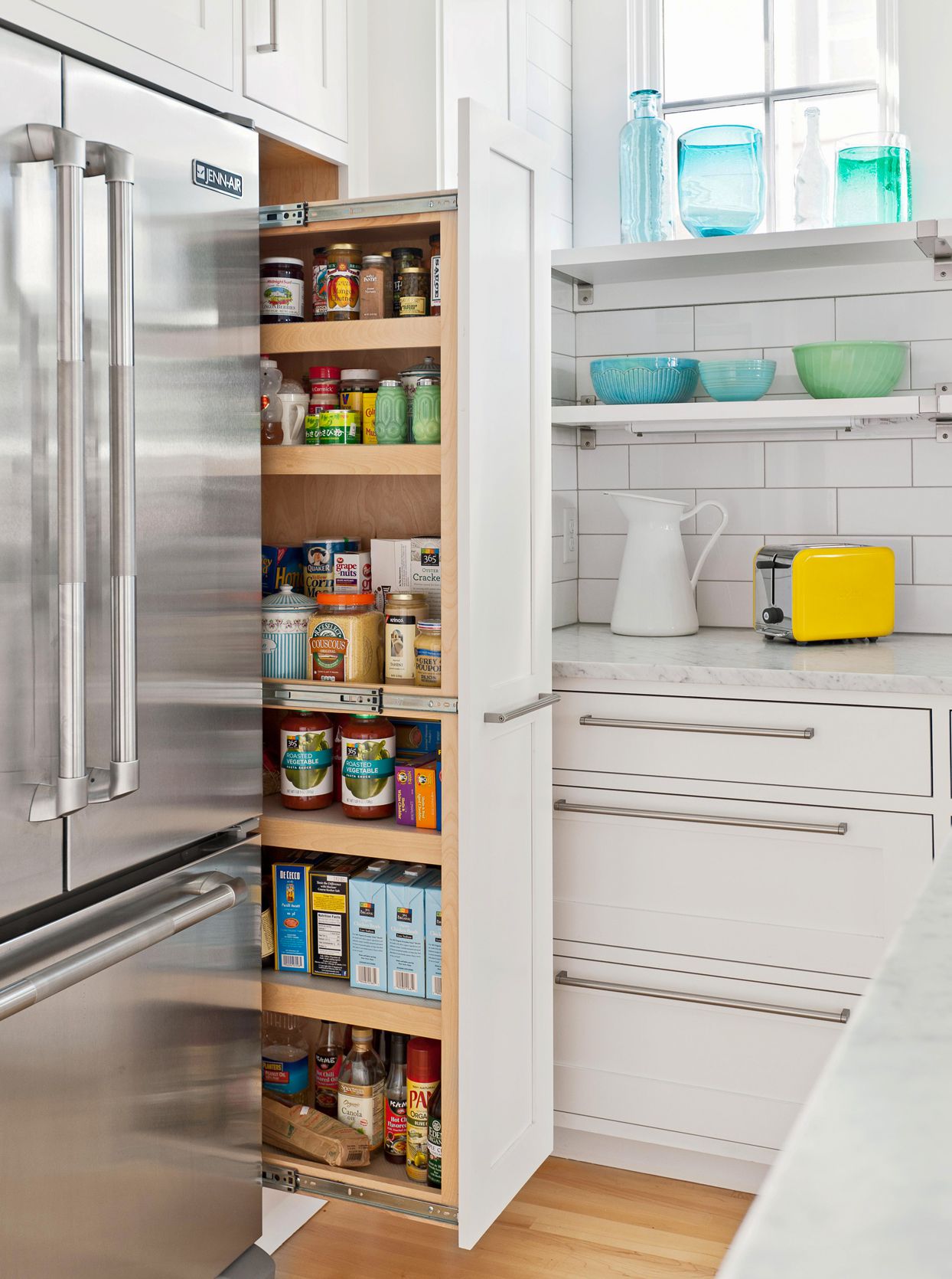 Slide-out kitchen pantry cabinet used to store appliances and pantry items efficiently