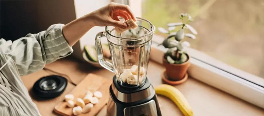 Blender jar with banana pieces added while the blender is powered on but not blending