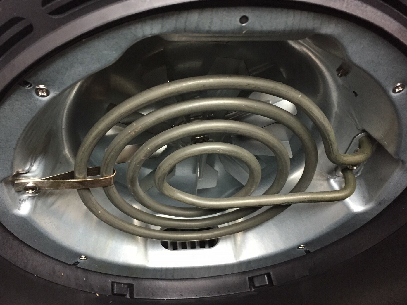 Interior of an air fryer showing the heating element and fan area where grease residue can accumulate over time
