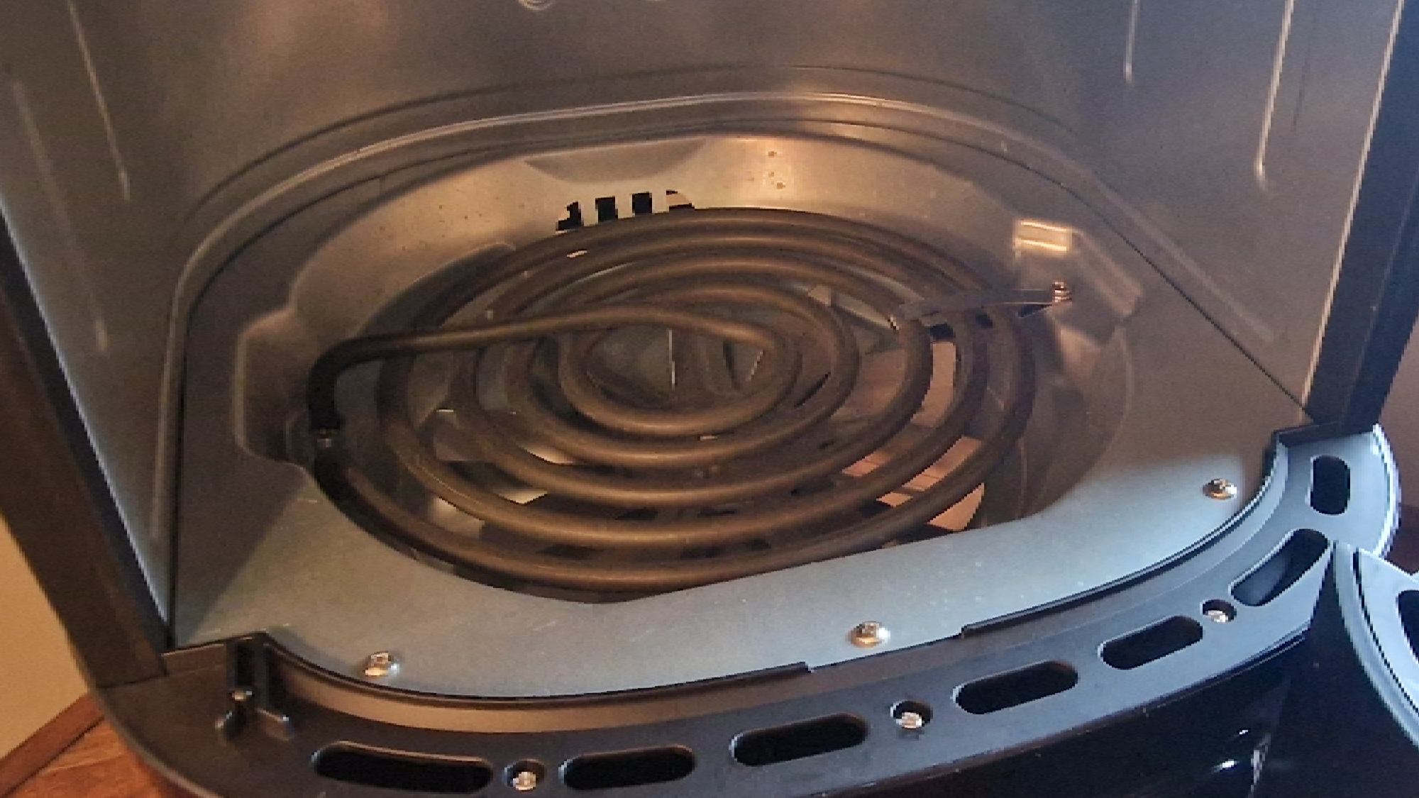 Interior of an air fryer showing the top-mounted heating element coil