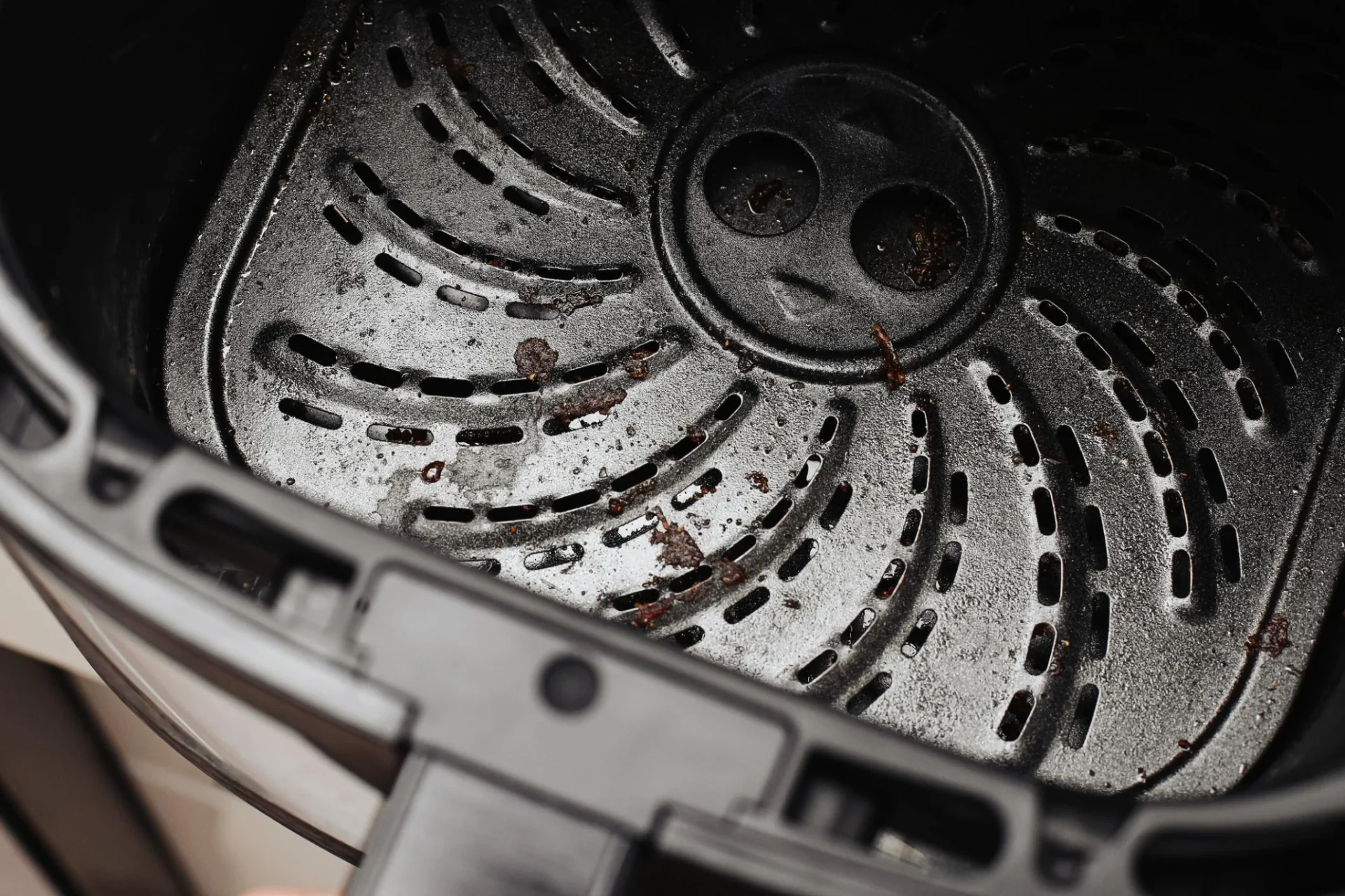 Air fryer basket interior showing grease buildup and food residue from repeated use