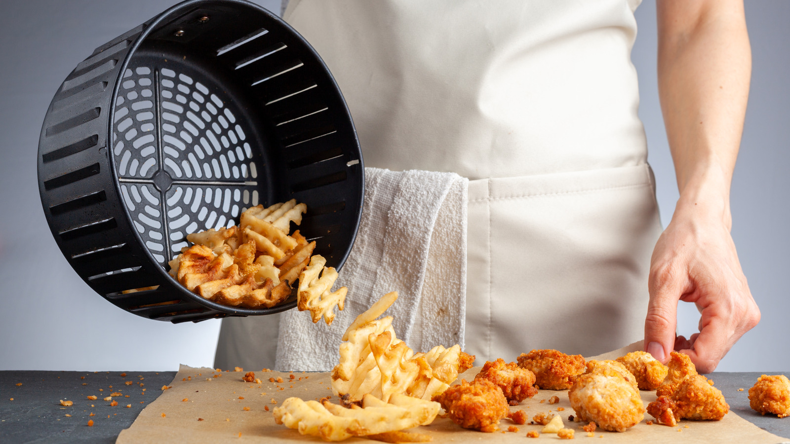 Overfilled air fryer basket with food stacked tightly, blocking proper airflow